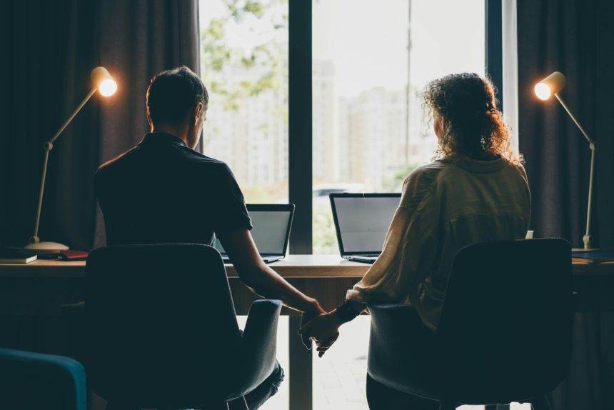 family of middle aged man and woman at work together on project with contemporary laptops